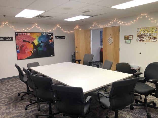 Group therapy room at Crossroads Program with chairs around table, motivational wall art, and welcoming space for addiction recovery meetings